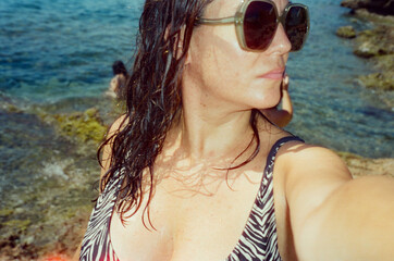 Woman on a beach with sunglasses and zebra bikini