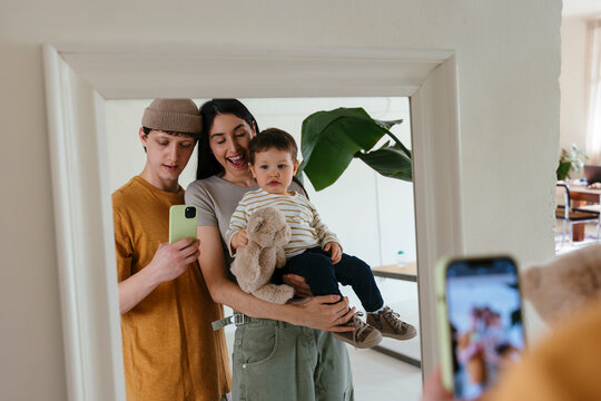 Father taking selfie with their family on mirror