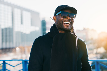 Smiling African American man enjoying sunny urban scenery