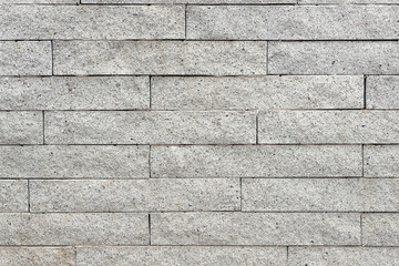 Texture of a natural stone wall made of rectangular blocks as an architectural background