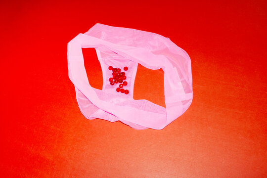 Conceptual photo of underpants and red pearls presenting period blood