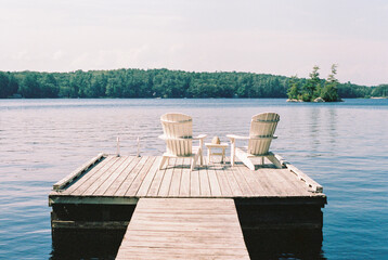 Two Chairs Sit on a Dock on a Summer Day in Biscay Pond in Maine  