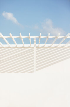 White pergola and shadows under a clear sky