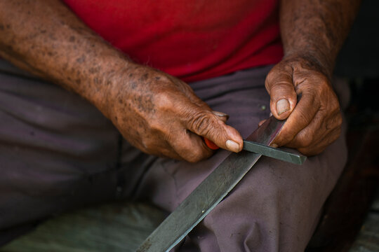 Farmer sharpening a machete