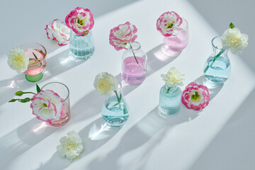 Glass vases with beautiful fresh eustoma flowers on table