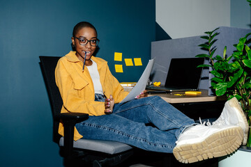 Woman at workplace with pencil in mouth