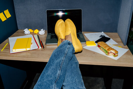 Office lunch, feet up in yellow shoes on desk