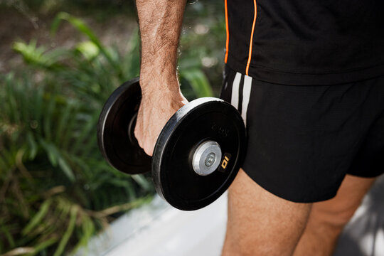 Man holding dumbbell outdoors for fitness exercise