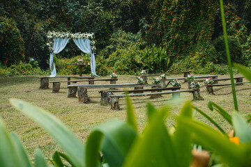 Tropical Forest Wedding Scene with Decorated Chairs and Arch