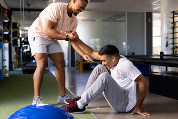 At rehabilitation center, biracial male physical therapist treating patient