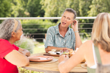 Diverse senior female friends sharing meal outdoors