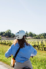 Woman on a bike exploring vineyards near near Saint-Émilion, Bordeaux region, France