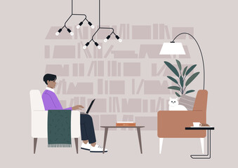 Fototapeta premium A person is working on a laptop in a cozy library, accompanied by a cat on a nearby chair, with modern lighting and bookshelves in the background