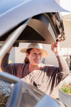 Woman closing car trunk