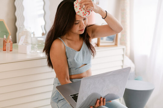 Woman with cold pack and laptop
