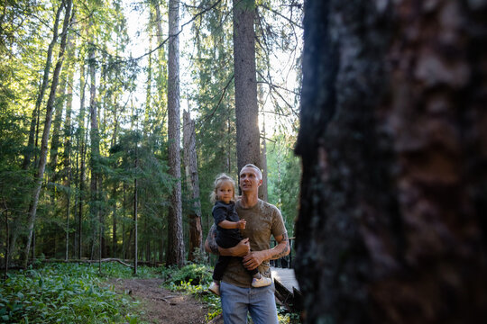 Man and his child on his shoulders the dense forest