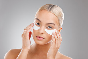 Woman, eye patch and beauty in studio portrait with process, skincare and wellness by white...