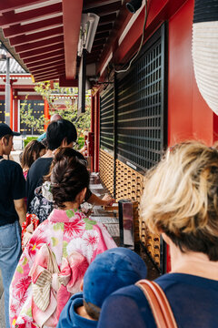 People lining up to get a fortune paper from a  random drawer in Tokyo