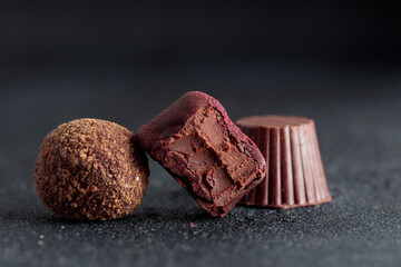 Delicious gourmet chocolate truffles from confectionery, homemade dark chocolate candies on black...