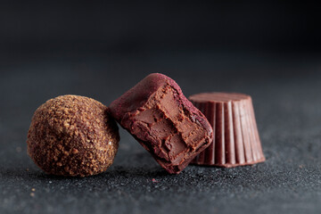 Delicious gourmet chocolate truffles from confectionery, homemade dark chocolate candies on black background