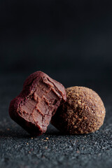 Delicious gourmet homemade dark chocolate candies from confectionery on black background