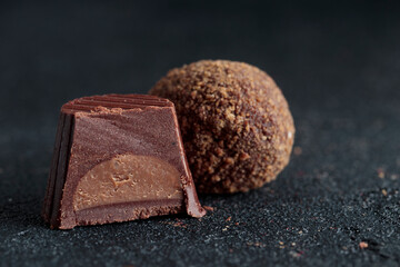 Delicious gourmet homemade dark chocolate candies from confectionery on black background