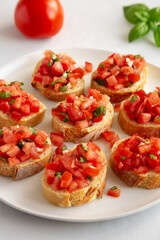 Homemade Bruschetta with Basil and Tomatoes on a Plate, side view.