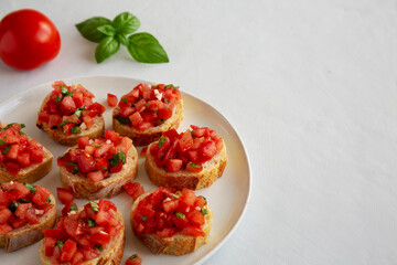 Homemade Bruschetta with Basil and Tomatoes on a Plate, side view. Copy space.