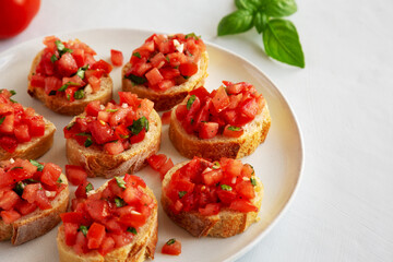 Homemade Bruschetta with Basil and Tomatoes on a Plate, side view.