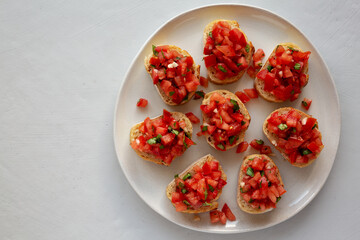 Homemade Bruschetta with Basil and Tomatoes on a Plate, top view. Copy space.