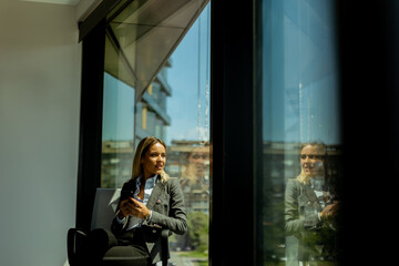 Businesswoman talking on phone in bright modern office on a sunny day