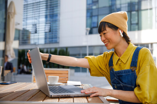 Happy freelancer using laptop at cafe