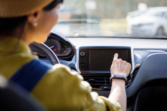 Woman using touch screen GPS in car - Powered by Adobe