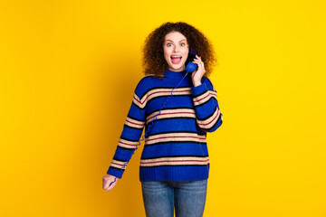 Portrait of impressed woman with wavy hair wear knit sweater hold landline phone astonished staring...
