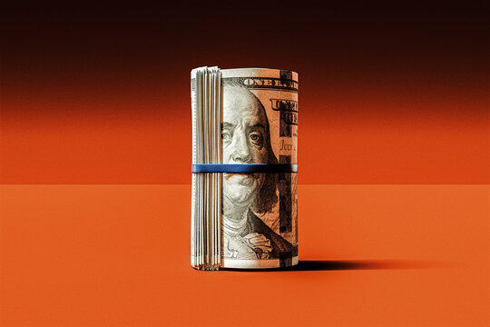 Roll Of $100 US Banknotes On Orange Background