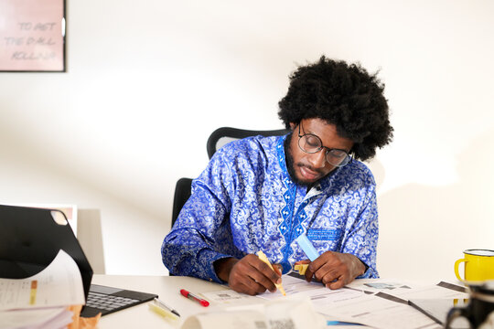 writing notes at a busy office desk 
