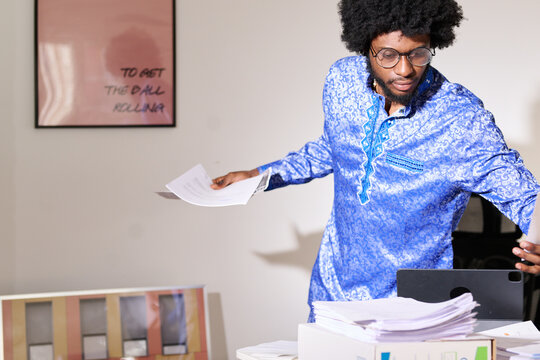 sorting papers at a cluttered office desk