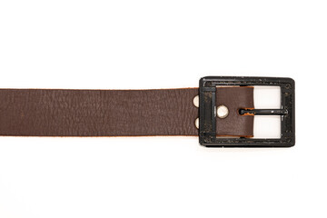 Worn Men's leather belt in a dark brown color with a metal buckle on white background. Top view or flat lay, close-up.