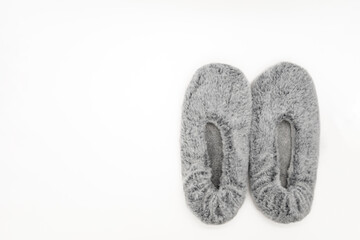 Fluffy gray home slippers isolated on white background. Bed shoes accessory footwear. Top view or flat lay.
