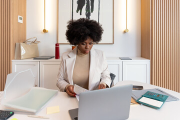 Focused black woman working with papers in office