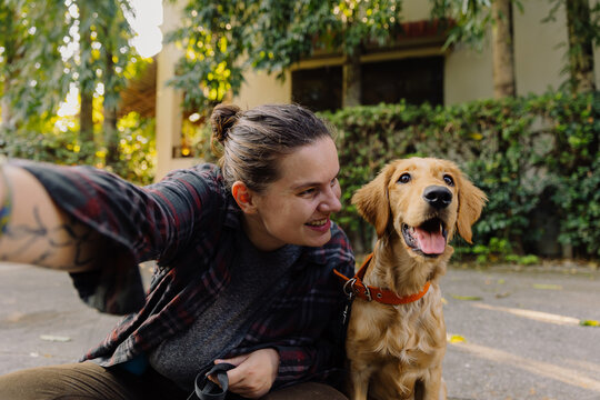 Happy owner with Golden Retriever dog taking selfie - Powered by Adobe