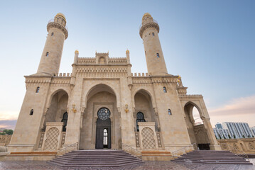 Obraz premium The majestic Taza Pir Mosque in Baku, Azerbaijan showcases intricate architecture with twin minarets against a peaceful early evening sky