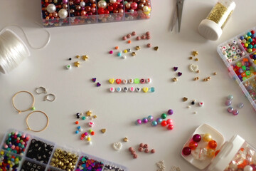 Friends forever written with colorful beads. Jewelry making supplies on the table. Making...