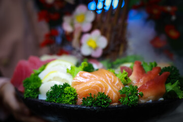 Authentic Japanese style sashimi plate. Fresh sashimi. Different types of seafood placed on a black...