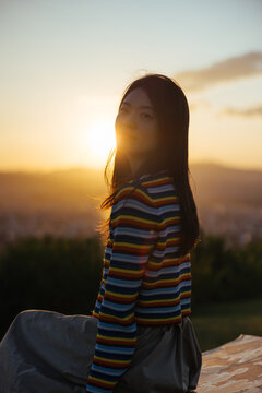 Woman in Sunset Light Overlooking City