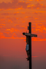 A cross with the figure of Jesus to heaven at sunset