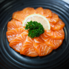 Salmon Sashimi in Japanese buffet restaurant menu. Fresh Sashimi fillet on black plate salmon slices. Salmon sashimi. Asian Food Menu. Seafood sashimi.