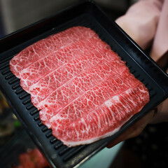 Fresh beef raw sliced with marbled texture.  beef slices Sliced ​​beef in a black plate on a black background.