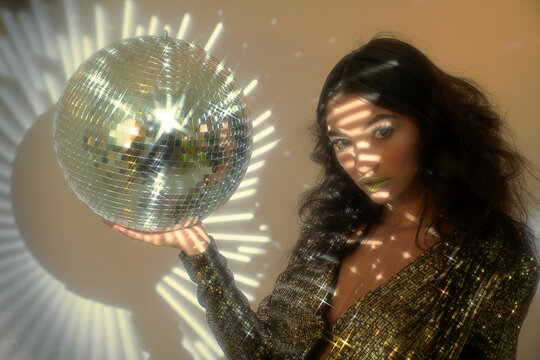 Golden Disco Woman Holding Shiny Ball under Light 