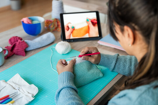 Creative woman handcrafting with online tutorial